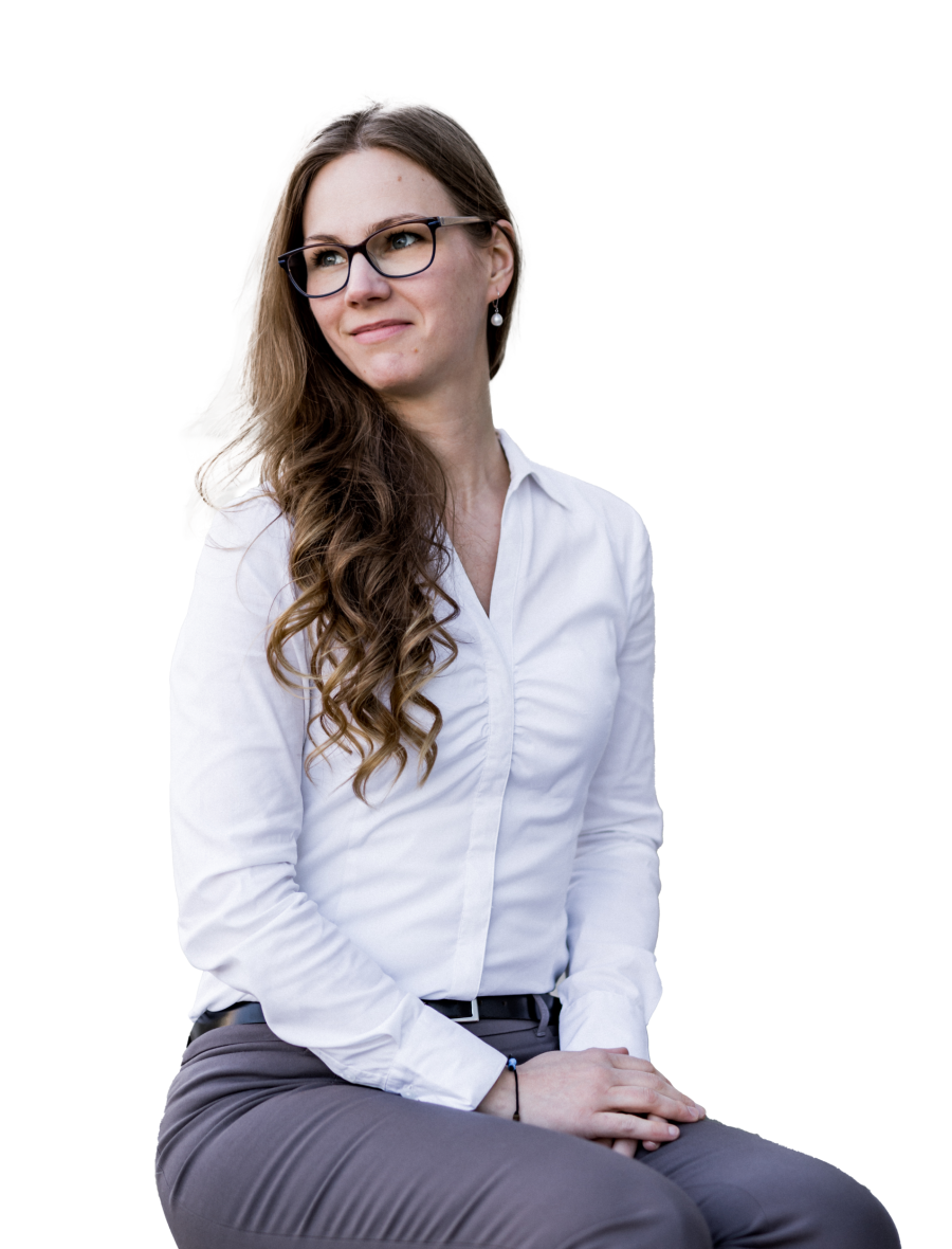 Melanie Eberle, Fotoausschnitt von Kopf bis Oberschenkel, freigestellt, sitzend in weißer Bluse, mit Brille, offenen Haaren über linker Schulter, schlichten Perlenohrringen, mit Blick nach rechts oben und freundlichem Gesichtsausdruck