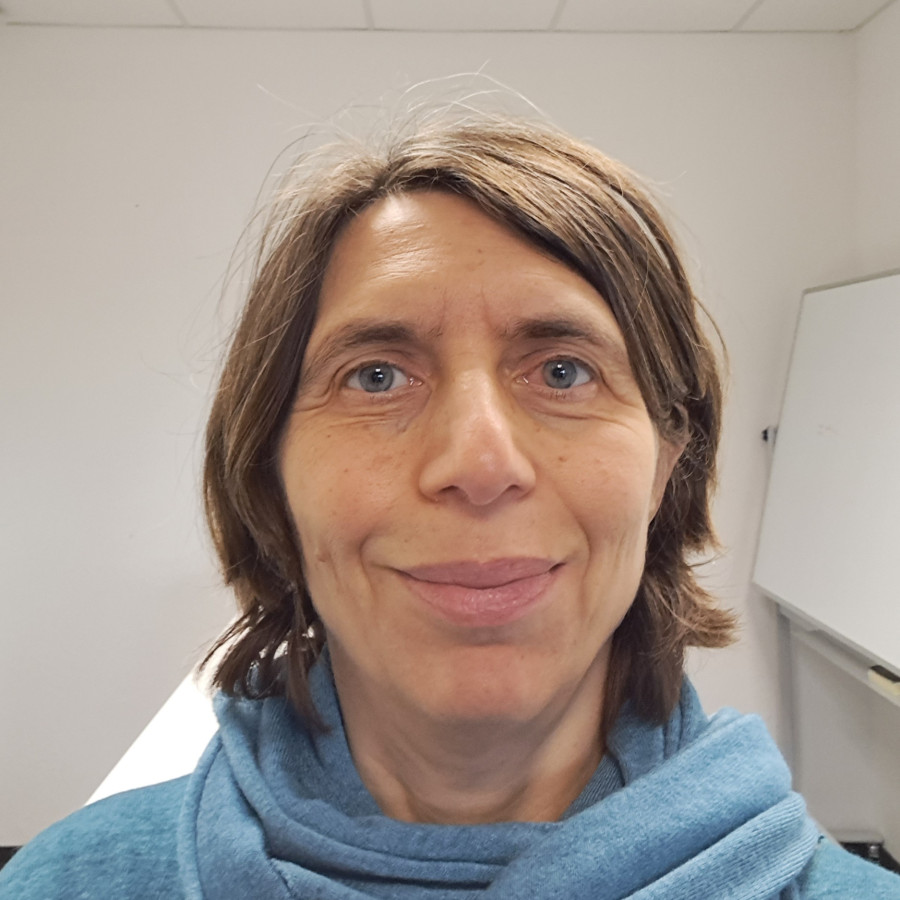 Maria Kaparaki, in blauem Rollkragenpulli, mit offenem Gesichtsausdruck